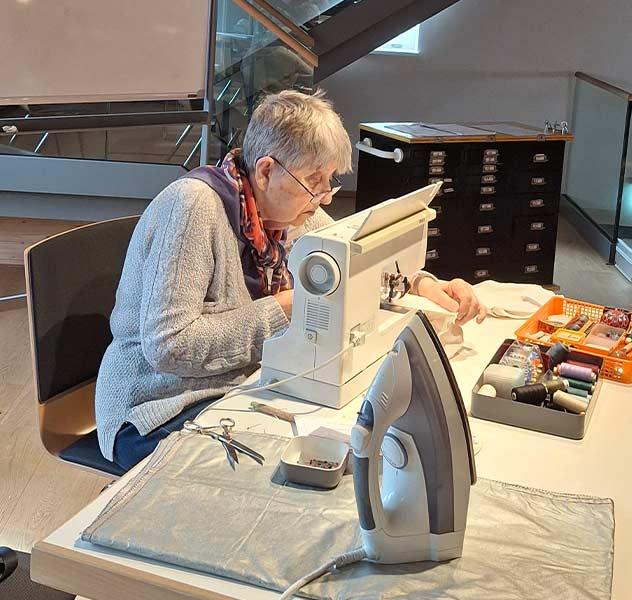 Eine Frau repariert etwas mit einer Nähmaschine im Repair-Café Uhingen