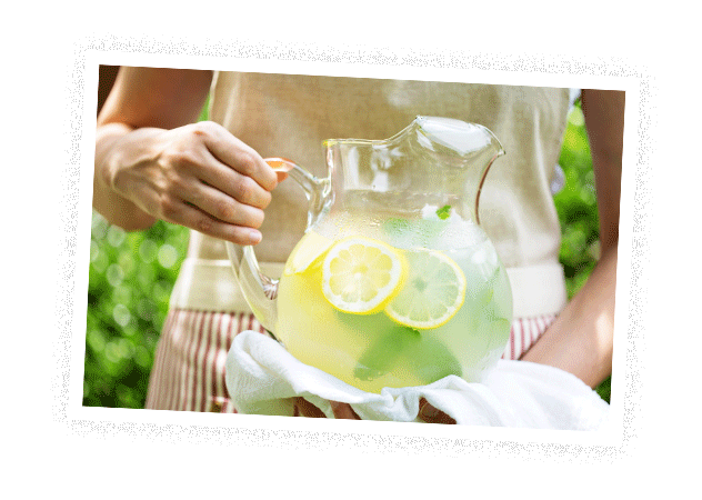 Eine Frau hält einen Krug mit Wasser, Zitronenscheiben und Minze –&nbsp;©Adobestock – fahrwasser