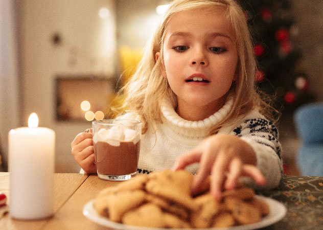 Mädchen mit Kakao und Weihnachtsplätzchen © AdobeStock – Drobot Dean Mädchen mit Kakao und Weihnachtsplätzchen – Team Klima