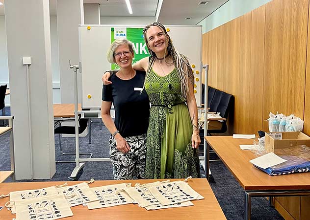 Astrid Geiger und Michelle Peschke vom Team Klima vor Tischen mit kleinen Beuteln für das Frühstück