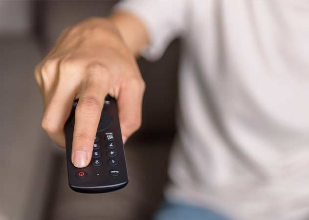 Hand auf einer Fernbedienung, die den Ausknopf drückt © Adobestock-Anucha 