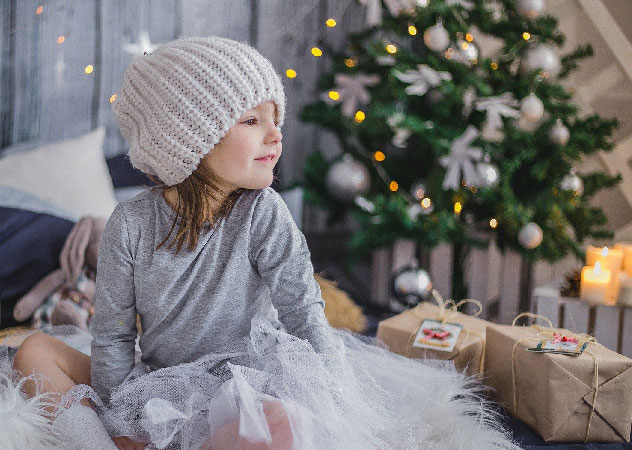Kind mit Weihnachtsbaum und Geschenken – Team Klima