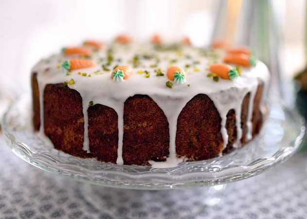 Karottenkuchen mit Frosting und Marzipankarotten auf einer Kuchenplatte – Pixabay congerdesign