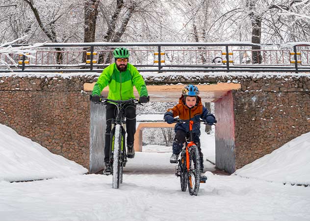 Mann und Kind beim Radfahren im Winter ©Adobestock – Alex Sipeta