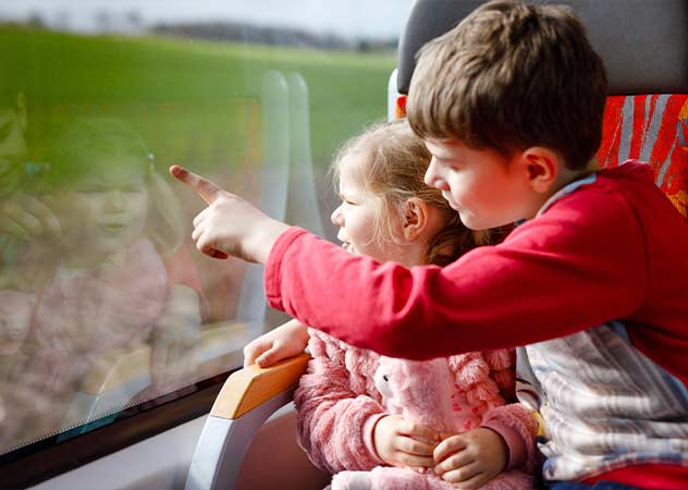Zwei Kinder schauen in einem Zug aus dem Fenster © Adobestock Irina Schmidt